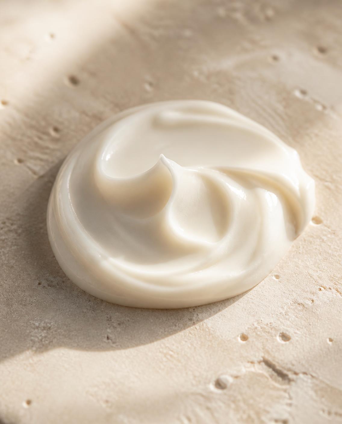 A swirl of rich peptide face cream on stone
